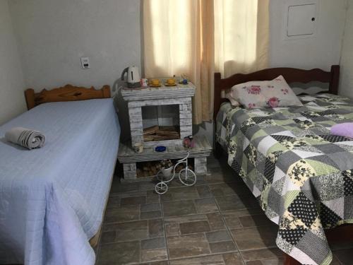 um quarto com duas camas e uma lareira em Cantinho Romântico e Encantador em Mairiporã