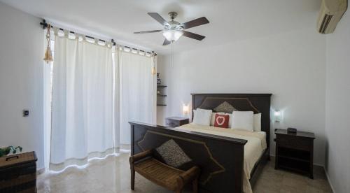a bedroom with a bed and a ceiling fan at Playa Village Condo by BVR in Playa del Carmen