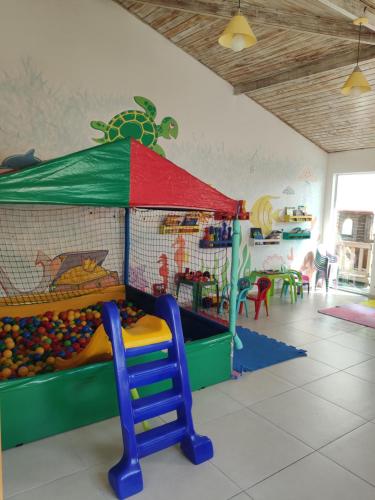 a childrens play room with a slide and play equipment at Le Bon Vivant, Nosso Lar in Arraial do Cabo