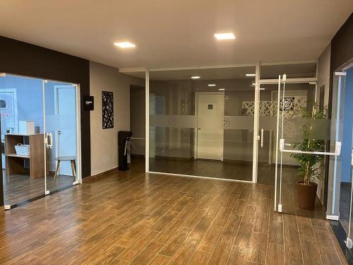 an empty office with glass doors and a wooden floor at Tulip Inn Sorocaba in Sorocaba