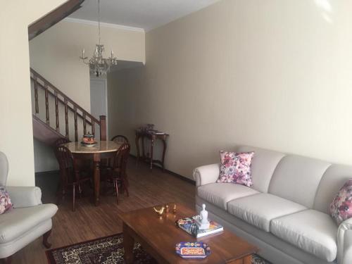a living room with a couch and a table at Center Suiço Flats in Campos do Jordão