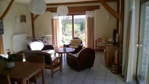 a living room with chairs and a table and a window at La P'tit' Fugue in La Bouexière