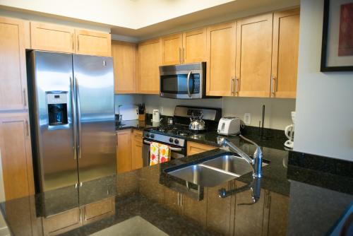 a kitchen with a stainless steel refrigerator and a sink at Crystal Quarters Corporate Housing at The Gramercy in Arlington