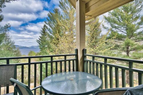 a table on a balcony with a view of the water at Tremblant Les Eaux by Rendez-Vous Mont-Tremblant in Mont-Tremblant