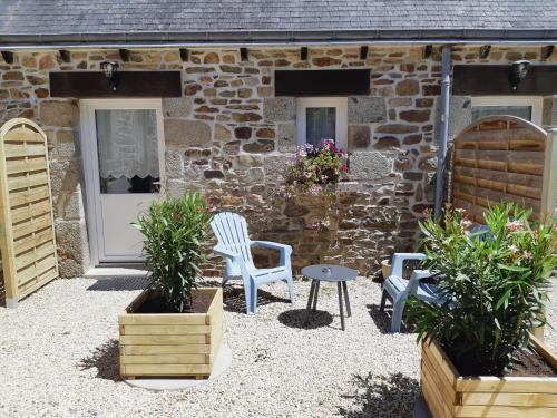 a stone cottage with two chairs and a table at L'Arche de Kerohan in Plouha