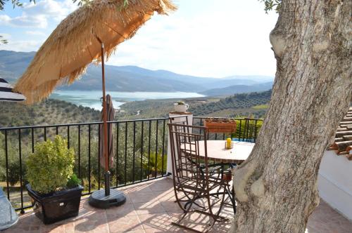 a table and chair on a balcony with a view at Casa De Ladera in Iznájar