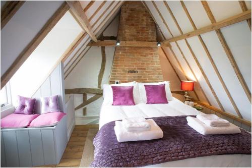 a bedroom with a large bed in a attic at The Cottage, High Ash Farm in Peasenhall