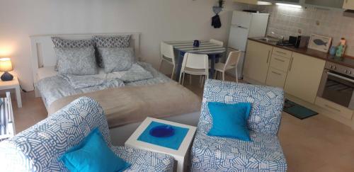 a living room with two couches and a kitchen at Victoria Wave Apartman in Balatonőszöd