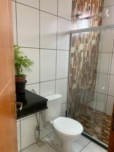 a bathroom with a toilet and a shower at CASA DE PRAIA COM PISCINA EM ILHÉUS-BA a 50m DA PRAIA in Ilhéus