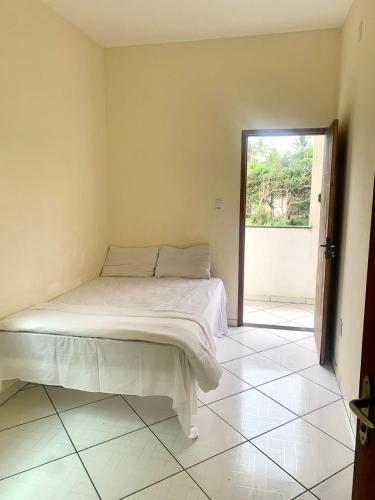 a bedroom with a bed in a room with a window at CASA DE PRAIA COM PISCINA EM ILHÉUS-BA a 50m DA PRAIA in Ilhéus