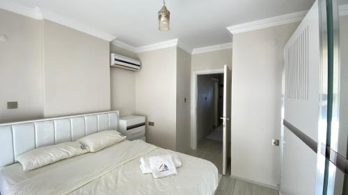 Dormitorio blanco con cama y pasillo en My White House, en Trabzon