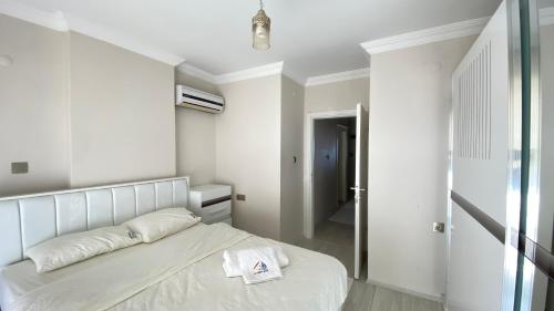 a white bedroom with a bed and a hallway at My White House in Trabzon