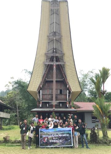 a group of people standing in front of a tower at Toraja Homestay & Coffee Bunna in Rantepao