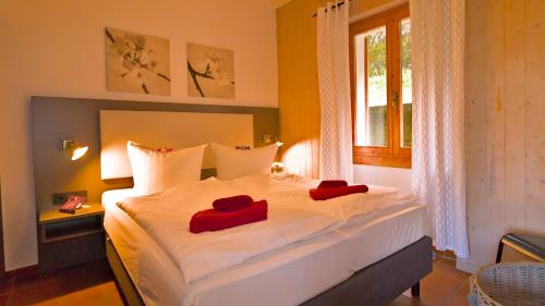 1 dormitorio con 1 cama con 2 almohadas rojas en Casa Anna, en Vesta