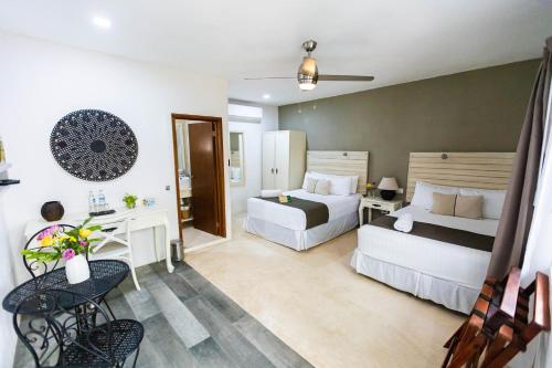 a hotel room with two beds and a desk at Hotel Siesta Holbox in Holbox Island