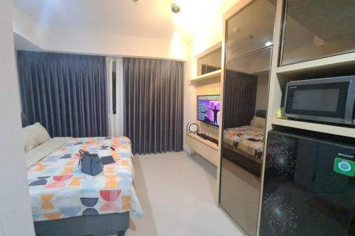 a hotel room with a bed and a tv in it at The Nove Apartment Junior Penthouse - Studio Type in Nongsa