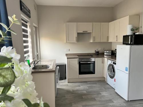 a kitchen with a white refrigerator and a dishwasher at Kim Family Holiday Get-Away 4 Bedrooms 2 Baths in Blackpool