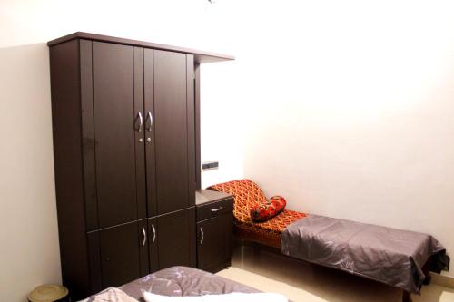 a bedroom with a large black cabinet and a bed at Sunny Daze in Cherai Beach