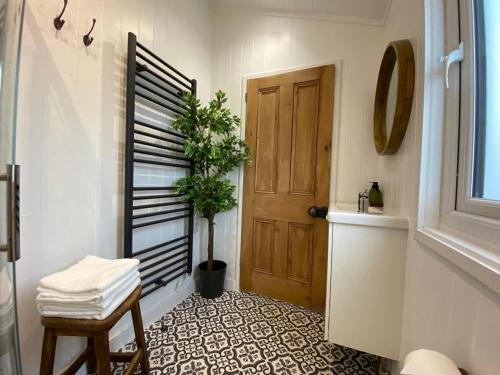 a bathroom with a door and a potted plant at Beachside Bliss Cosy Cottage Jurys Gap in Rye