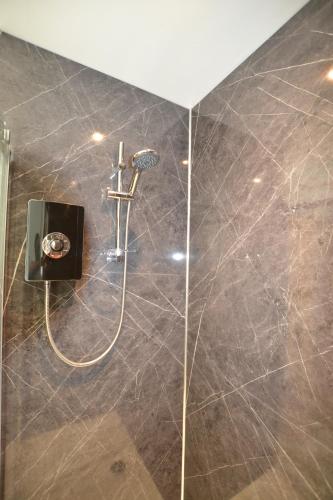 a shower with a shower head in a bathroom at Thomas 1 bed Apartment with cathedral views - STAYSEEKERS in Salisbury