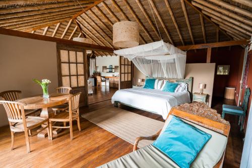 een slaapkamer met een bed en een tafel in een kamer bij Villa Del Sol in Máncora