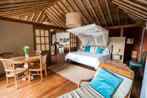a bedroom with a bed and a table in a room at Villa Del Sol in Máncora