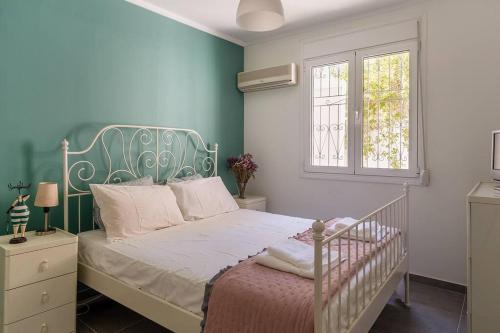 a bedroom with a white bed and a window at Bunny island- seaview house, private garden , Lagonisi, Attika riviera in Kalívia Thorikoú