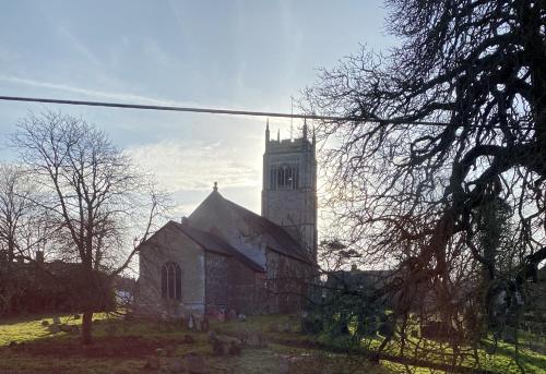 an old church with a tower and a steeple at Kings Head Low House in Laxfield