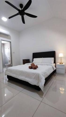 a bedroom with a large bed with a ceiling fan at Ipoh Sunway Tambun Spacious Homestay in Ipoh