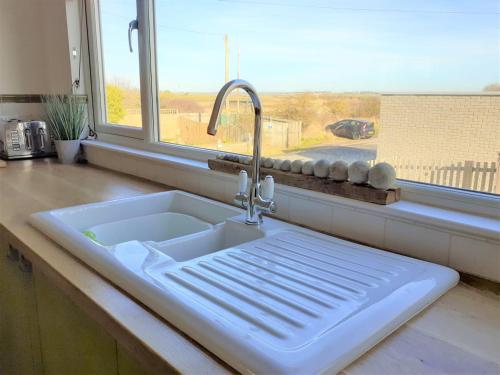 a white sink in a kitchen with a window at Normans Bay Charm The Crabshack Cottage in Pevensey