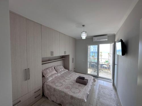 een witte slaapkamer met een bed en een raam bij Sea view Shengjin in Shëngjin