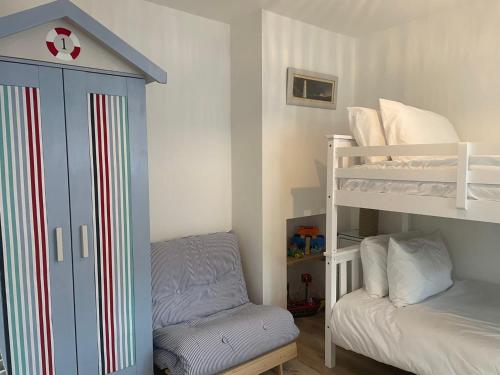 a small bedroom with a bunk bed and a bunk bedkamp at Normans Bay Charm The Crabshack Cottage in Pevensey