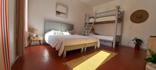 a bedroom with a bed and a bunk bed at La maison de Malaurie in Gruissan