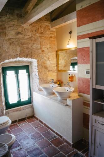 a bathroom with two sinks and a window at Neroli Place in Svetvinčenat