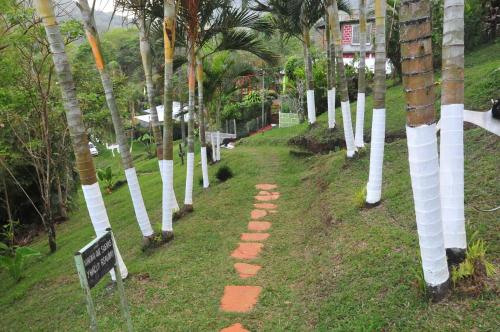 a pathway with white trees in a park with a sign at Cabañas Ecobiosfera in Catemaco