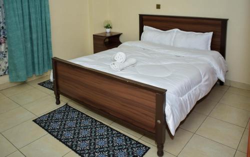 - une chambre avec un grand lit et 2 serviettes dans l'établissement Lux Suites 2 Bedroom Diamonte Apartment Ngara, à Nairobi