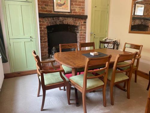 a dining room with a table and chairs and a fireplace at Spacious 4-Bed Beach Retreat for Families Steps from the Shore in Pevensey Bay in Pevensey