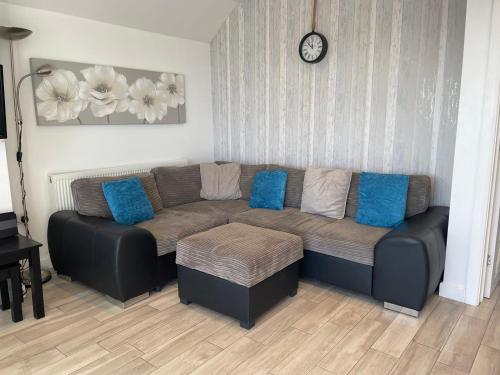 a couch with blue pillows in a living room at Coastview Bungalow in Pevensey