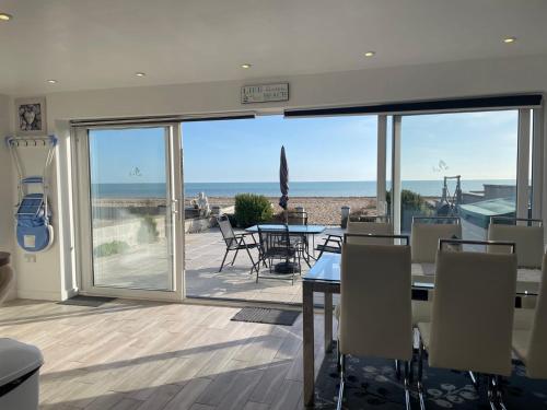 a dining room with a view of the ocean at Coastview Bungalow in Pevensey