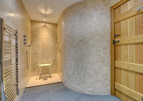 a bathroom with a walk in shower next to a wall at The Stables Lynton in Lynmouth