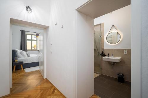 een badkamer met een wastafel en een spiegel bij CoView - Bautzen - Design Apartment in der Altstadt mit fantastischem Ausblick in Bautzen