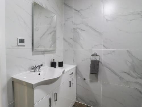 a white bathroom with a sink and a mirror at Moorbottom Stables in Halifax