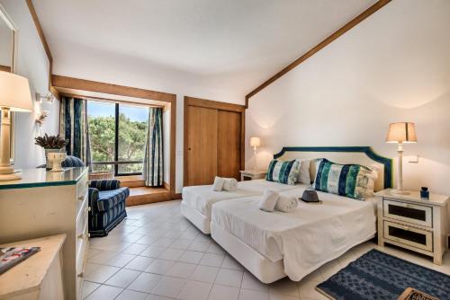 una camera d'albergo con due letti e una finestra di Victory Village Beach Villa - Quinta do Lago a Quinta do Lago