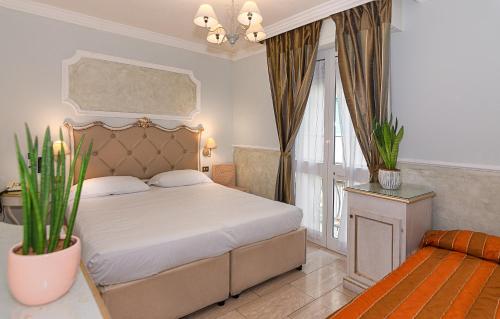 a bedroom with a white bed and a window at Hotel Tahiti in Viareggio