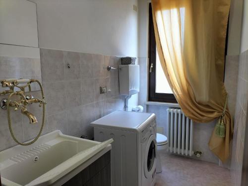 a bathroom with a washing machine and a sink at Casa Degli Ulivi in Lazise
