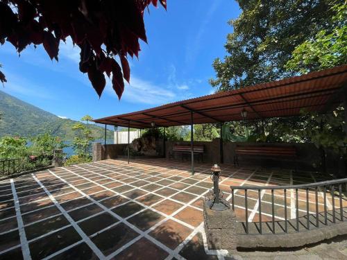a patio with a bench and an umbrella at Hotel Tiosh Abaj in Santiago Atitlán