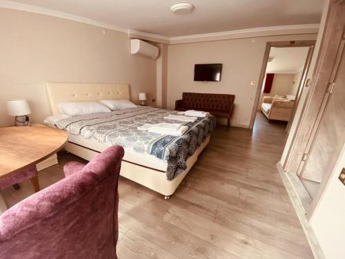 a bedroom with a bed and a table and chairs at Pelitpark Apart in Pelitli