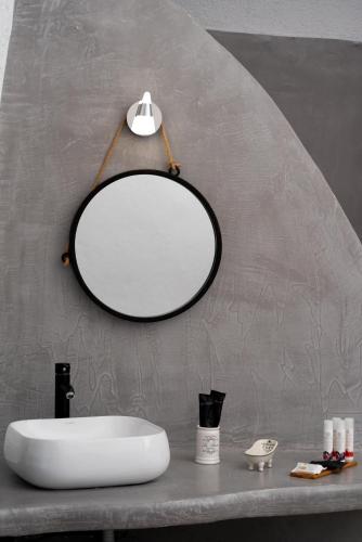 a bathroom with a white sink and a mirror at 1812 Caves 'n Mansion in Karterados