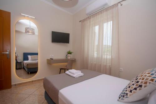 um quarto de hotel com uma cama e um espelho em Villa Kalliestia, sea view veranda and garden em Kissamos