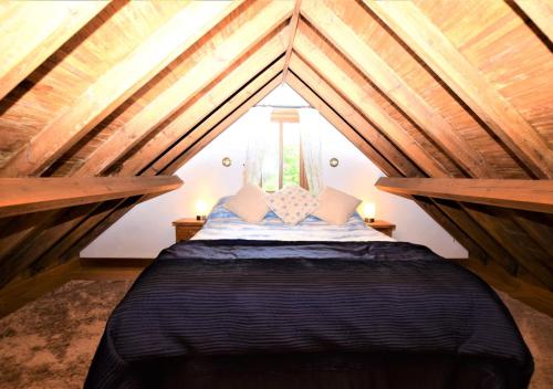 um quarto com uma cama num sótão em Corner Barn em North Burlingham